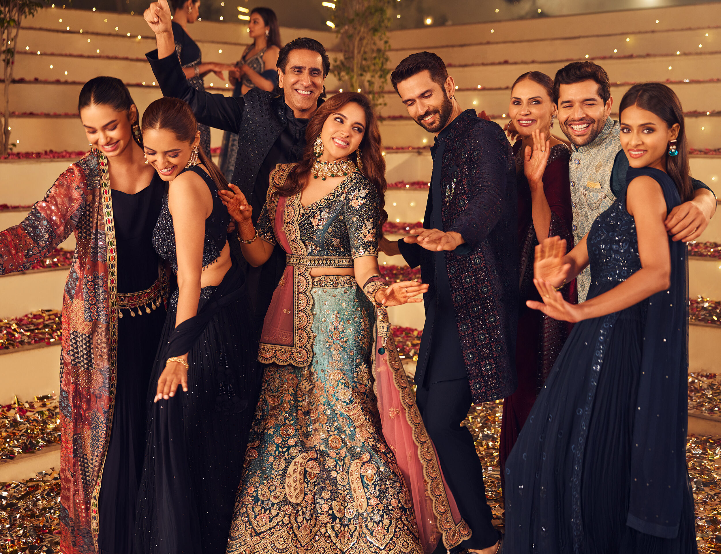 Mens and womens dancing wearing elegant sherwanis and lehengas for wedding